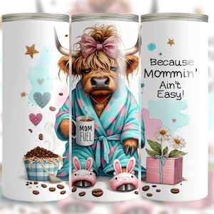 A funny Highland cow in a polka-dot robe, pink bunny slippers, and coquette bow holding a "Mom Fuel" mug, surrounded by coffee beans, glitter hearts, daisies, and a pink gift box. Text reads, "Because Mommin’ Ain’t Easy!" on a playful background.
