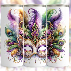 May include: A white tumbler with a colorful Mardi Gras mask design. The mask is decorated with gold, purple, green, and gold feathers. The mask has a white background with gold and purple accents.