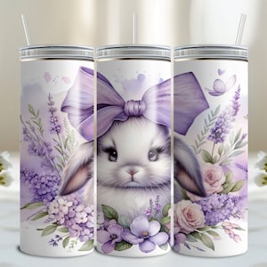 A beautiful 20 oz tumbler wrap featuring an adorable white Easter bunny with big, expressive eyes, wearing a large purple bow. Surrounded by soft pastel florals, lavender, and butterflies in a dreamy watercolor style on a white background