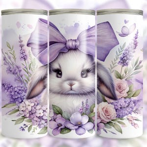 A beautiful 20 oz tumbler wrap featuring an adorable white Easter bunny with big, expressive eyes, wearing a large purple bow. Surrounded by soft pastel florals, lavender, and butterflies in a dreamy watercolor style on a white background