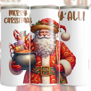 Op de afbeelding: Witte beker met een feestelijk ontwerp van de kerstman in een rood en goud pak, met een pot rivierkreeften en cadeaus. De teksten "Merry Christmas" en "Y'all" zijn in rood en groen weergegeven.
