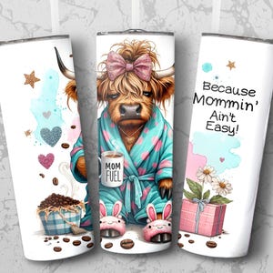A funny Highland cow in a polka-dot robe, pink bunny slippers, and coquette bow holding a "Mom Fuel" mug, surrounded by coffee beans, glitter hearts, daisies, and a pink gift box. Text reads, "Because Mommin’ Ain’t Easy!" on a playful background.