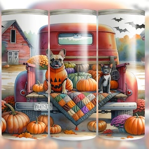 Op de afbeelding: Tumbler met een rode vintage truck vol pompoenen, een Franse bulldog in een pompoenkostuum en een grijze kat. Een kleurrijke quilt en herfstbladeren maken de herfstscène compleet.