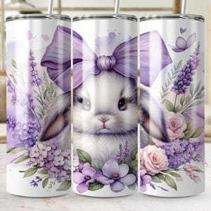 A beautiful 20 oz tumbler wrap featuring an adorable white Easter bunny with big, expressive eyes, wearing a large purple bow. Surrounded by soft pastel florals, lavender, and butterflies in a dreamy watercolor style on a white background