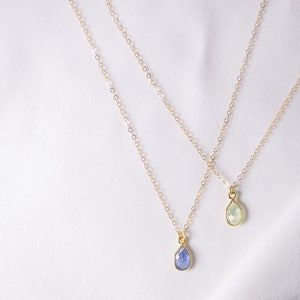 Puede incluir: Dos collares de oro con colgantes en forma de l&aacute;grima de piedra preciosa. Un colgante es de color azul claro y el otro es de color verde claro.