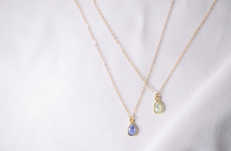 Puede incluir: Dos collares de oro con colgantes en forma de l&aacute;grima de piedra preciosa. Un colgante es de color azul claro y el otro es de color verde claro.