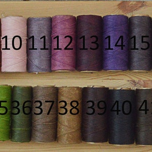 May include: A wooden board with 50 spools of thread in various colors. The spools are numbered 1 through 50.