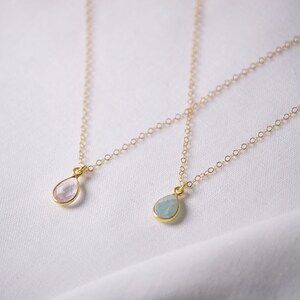 Puede incluir: Dos collares de oro con colgantes en forma de l&aacute;grima. Un colgante es una piedra preciosa rosa claro, y el otro es una piedra preciosa azul claro.