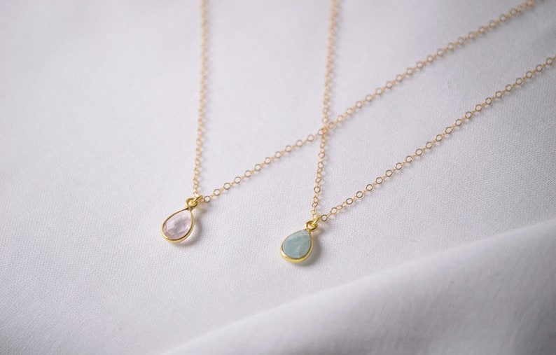 Puede incluir: Dos collares de oro con colgantes en forma de l&aacute;grima. Un colgante es una piedra preciosa rosa claro, y el otro es una piedra preciosa azul claro.