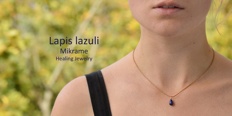 May include: A gold chain necklace with a teardrop-shaped lapis lazuli pendant. The necklace is worn by a person with a black tank top. The text "Lapis lazuli Mikrame Healing Jewelry" is visible in the image.
