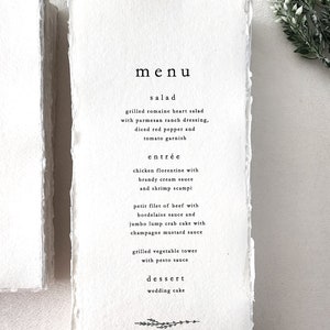 Custom wedding menu printed on handmade cotton rag deckle edge paper with minimalist black typography, shown in a 4x9 format.
