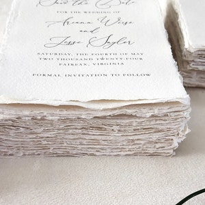 Stacks of custom wedding invitations, RSVP and details cards printed on handmade cotton rag deckle edge paper, showing the natural texture and torn edges.