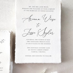 Custom wedding invitation printed on handmade cotton rag deckle edge paper with elegant black calligraphy and classic typography, showing the natural paper texture and torn edges.