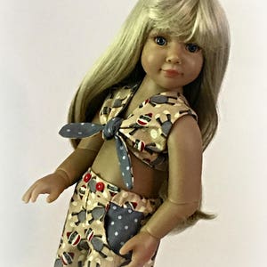 May include: A doll wearing a beige and brown sleeveless top with a blue and white polka dot tie, and matching shorts with a blue and white polka dot pocket. The doll has long blonde hair and blue eyes. The text "Sew Dolled Up 81" is visible in the bottom right corner of the image.
