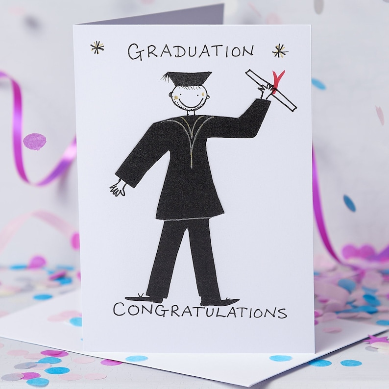 May include: A white card with a black and white illustration of a person in a graduation cap and gown holding a diploma. The text "GRADUATION" is written in gold lettering at the top of the card. The text "CONGRATULATIONS" is written at the bottom of the card.