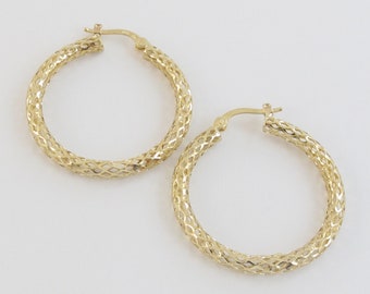 May include: A pair of gold hoop earrings with a delicate, woven design.