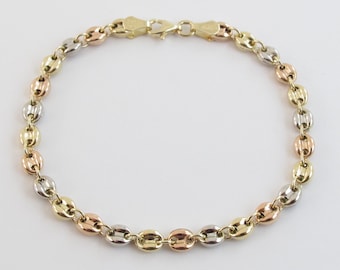 May include: A gold bracelet with a chain made of alternating oval links in yellow, white, and rose gold.