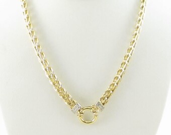 May include: A gold chain necklace with a round, open-circle pendant. The pendant is accented with small, clear stones.