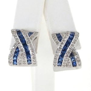 May include: A pair of silver earrings with a criss-cross design featuring blue and white gemstones.