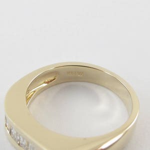 May include: A gold band ring with a row of small diamonds set into the band. The inside of the band is marked "14K 14".