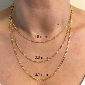 May include: Three gold-colored chain necklaces of varying thicknesses are displayed. The chains are 1.8 mm, 2.3 mm, and 3.1 mm thick. The necklaces are around a person's neck, showcasing the different chain styles and sizes.