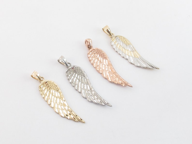 Op de afbeelding: Vier engelenvleugel hangers in verschillende metaal afwerkingen: goud, zilver, ros&eacute; goud en tweekleurig goud en zilver.