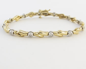 May include: A gold and silver bracelet with a wavy design and small round diamonds.