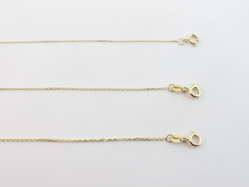 May include: Three gold chains of different lengths, each with a lobster clasp.