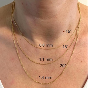 May include: Three gold-colored necklaces of varying lengths, displayed on a person's neck. The shortest necklace is labeled "16", the middle one "18", and the longest "20". The chain thicknesses are labeled as 0.8 mm, 1.1 mm, and 1.4 mm.
