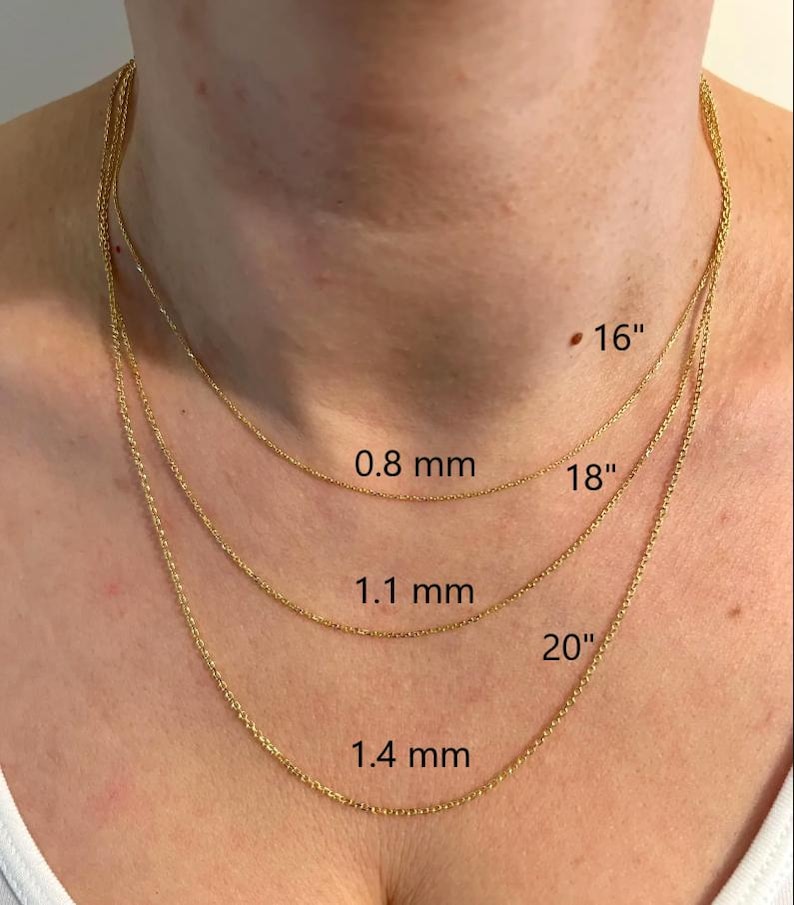 May include: Three gold-colored necklaces of varying lengths, displayed on a person's neck. The shortest necklace is labeled "16", the middle one "18", and the longest "20". The chain thicknesses are labeled as 0.8 mm, 1.1 mm, and 1.4 mm.