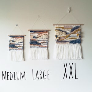Three woven wall hangings in varying sizes; small, medium, and large.  The hangings feature a similar design with a color palette of off-white, beige, gray, and mustard yellow.  Each piece has a white fringe at the bottom. The sizes are labeled as 'MEDIUM', 'LARGE', and 'XXL' below the hangings.