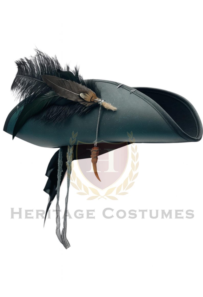 Puede incluir: Un sombrero de tres picos de color verde oscuro con un grupo de plumas negras y marrones en el lateral. Una cadena plateada cuelga de la base de las plumas, conectada a un peque&ntilde;o dije curvo de color marr&oacute;n claro con forma de cuerno. Dos cintas de tela fina y deshilachada cuelgan.