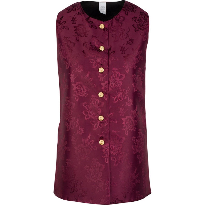 May include: A sleeveless vest in a deep burgundy color featuring a tonal floral jacquard pattern throughout. The garment has a round neckline and a front button closure with five circular gold-toned buttons. The interior lining is black.