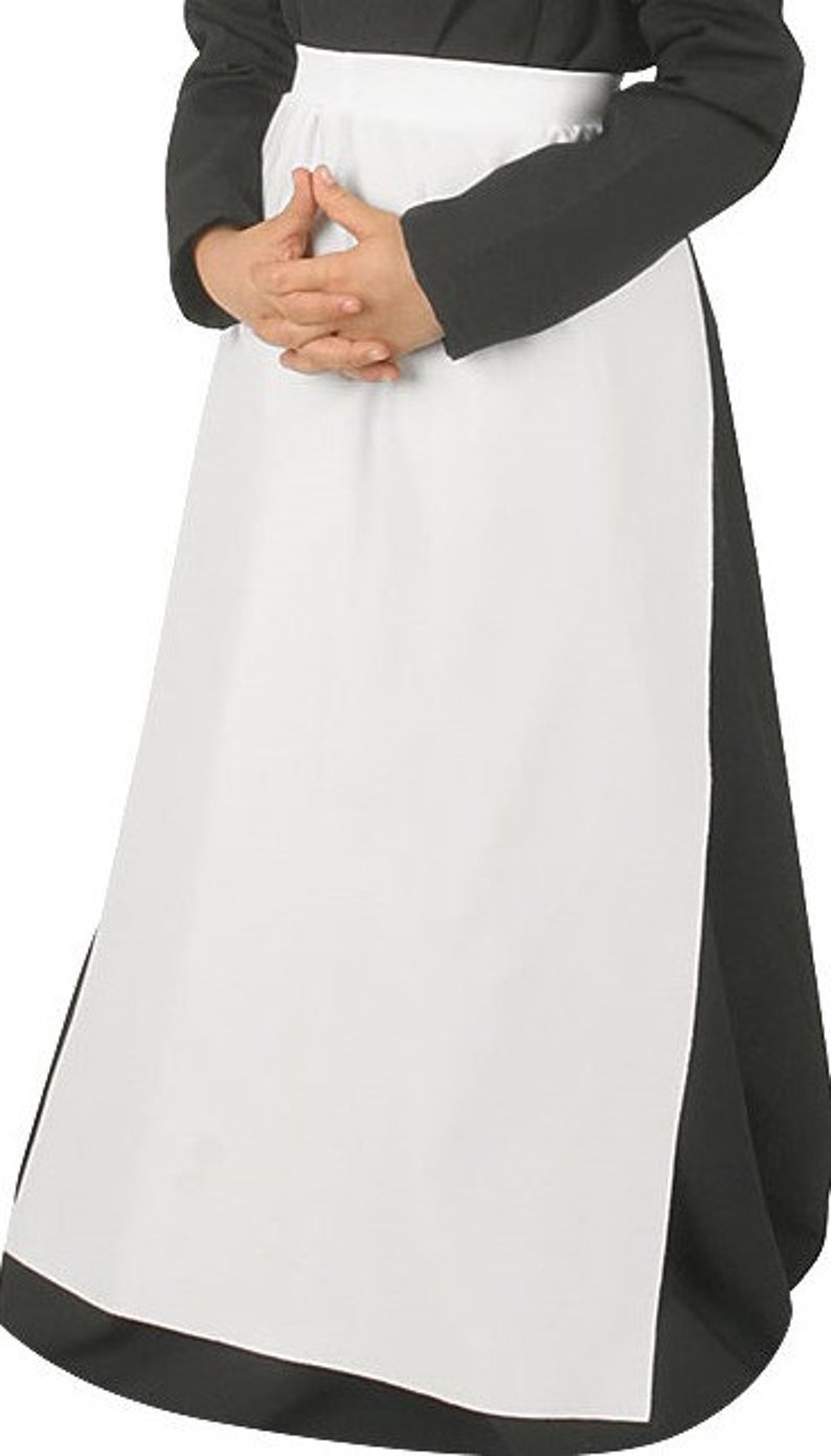 May include: A long white apron worn over a black long-sleeved garment. The apron features a wide waistband and a smooth, plain white fabric panel that extends down to the hem, contrasting against the solid black fabric of the underlying clothing.