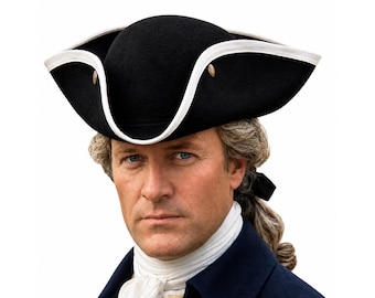 May include: A black tricorn hat featuring a white trim along the upturned brim and metallic gold-toned buttons on the sides. The hat is worn over a white cravat and a dark blue coat, with a light-colored wig visible underneath the hat.