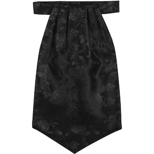 May include: A black cravat featuring a tonal rose floral pattern throughout the fabric. The neckwear has a wide, pointed bottom edge and a pleated top section that connects to a horizontal neck band, creating a formal and structured appearance.