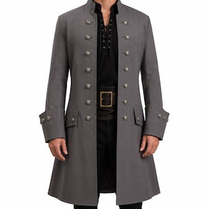 May include: A long grey coat featuring a high collar, long sleeves with decorative buttons at the cuffs, and two vertical rows of metallic buttons down the front. The coat is worn over a black shirt with a lace-up neckline and a black belt.