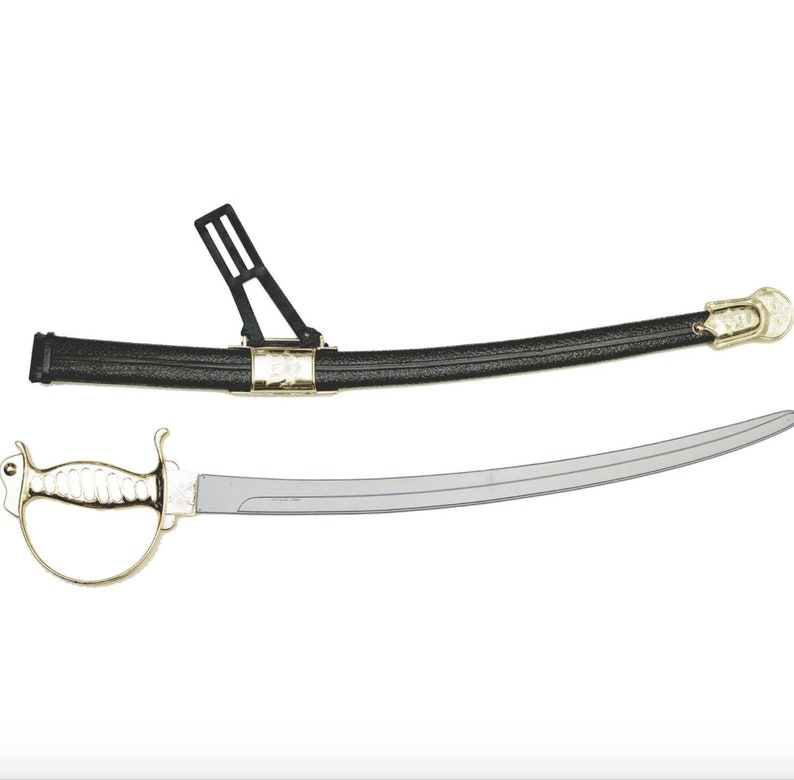 May include: A curved sword with a polished silver-tone blade and a gold-tone hilt featuring a hand guard. The accompanying black scabbard has a textured finish, gold-tone metal accents, and a black plastic belt attachment loop for carrying.
