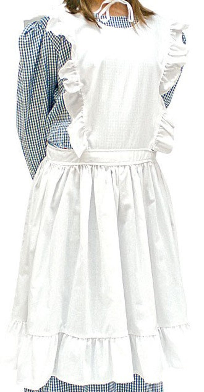 May include: A blue and white gingham dress featuring long sleeves and a high neckline, paired with a white apron. The apron has ruffled shoulder straps, a waistband, and a gathered skirt with a ruffled hemline that falls below the knees.