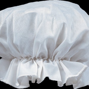 May include: A white fabric bonnet featuring a gathered, rounded crown and a ruffled brim. The headwear is constructed from a lightweight, semi-sheer material with visible woven texture, showcasing a classic design with soft folds throughout the fabric.