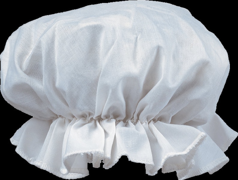 May include: A white fabric bonnet featuring a gathered, rounded crown and a ruffled brim. The headwear is constructed from a lightweight, semi-sheer material with visible woven texture, showcasing a classic design with soft folds throughout the fabric.