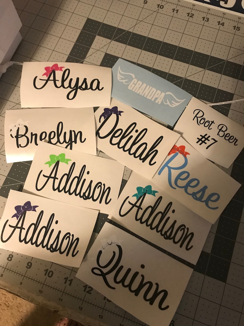 Puede incluir: Una colecci&oacute;n de calcoman&iacute;as de vinilo personalizadas con nombres como Alyssa, Breelyn, Delilah, Addison, Reese y Quinn. Algunas calcoman&iacute;as presentan lazos y el texto "Grandpa" y "Root Beer #7".