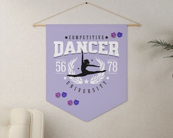 May include: A lavender banner with the words "COMPETITIVE DANCER UNIVERSITY" in white. A silhouette of a dancer in mid-air is centered on the banner. The banner is held by a wooden rod and string.