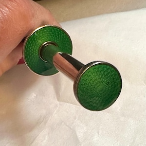 Peut inclure: Une pince à sucre en argent avec des extrémités en émail vert. L'émail a un motif texturé.
