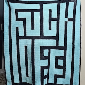 May include: A crocheted blanket with a geometric pattern in black and light blue. The pattern resembles a maze.