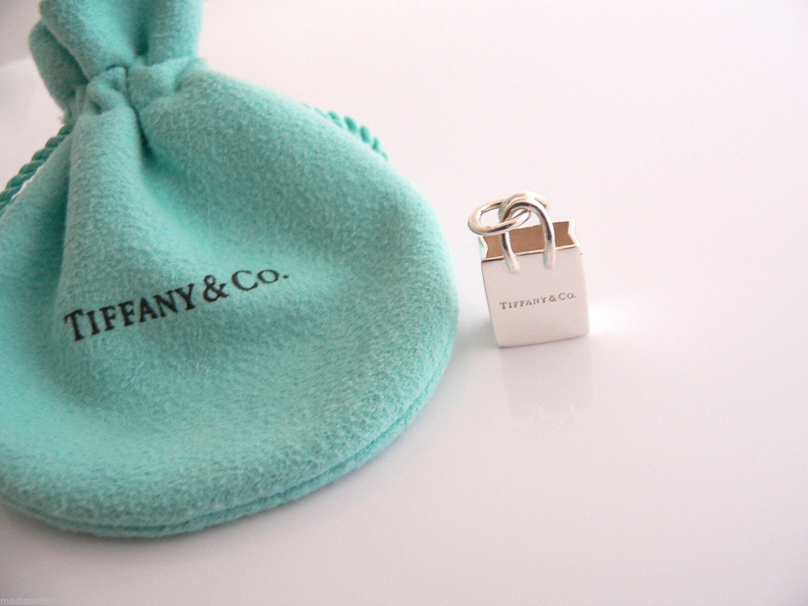Tiffany & Co.® shopping bag charm in sterling silver with enamel finish.