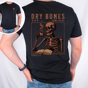 May include: Black t-shirt with a graphic of a skeleton holding a cup of coffee and reading a book. The text "DRY BONES COME ALIVE" and "EZEKIEL 37:5" are printed on the shirt.