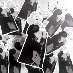 Könnte beinhalten: Eine Ansammlung von Aufklebern mit einer Schwarz-Weiß-Illustration einer Frau in einem schwarzen Kleid mit Spitzenkragen, erhobenen Armen und offenem Mund. Die Aufkleber haben einen weißen Rand und liegen auf einer grauen Oberfläche.