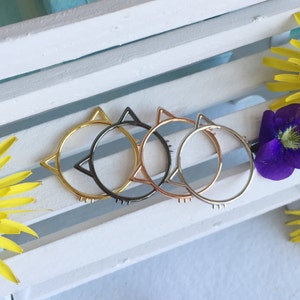 Op de afbeelding: Vier ringen in de vorm van een kat in verschillende metaalafwerkingen: goud, rosé goud, zilver en zwart.