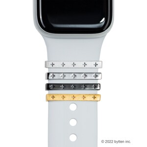 Może przedstawiać: Cztery metalowe paski w różnych kolorach z wzorem krzyża do zegarka Apple Watch. Paski są srebrne, chromowane, czarne i złote.